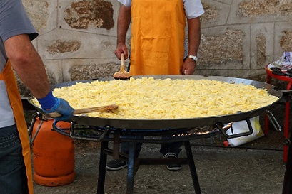 giant omelette on a pan with two people cooking